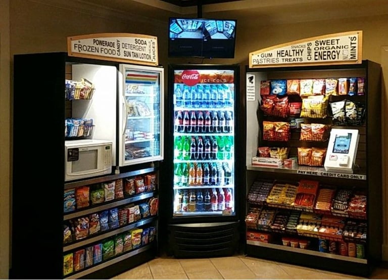 Row of vending machines offering frozen food, beverages, and snacks in a convenience store setting