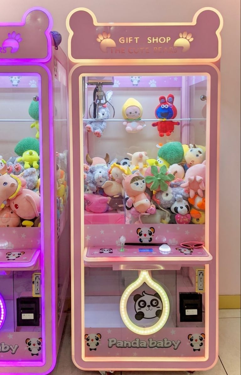Neon-lit panda-themed gift shop claw machine arcade game filled with plush toys and collectible figurines