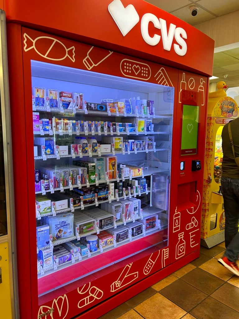 Red CVS vending machine with illuminated display stocked with various health and beauty products inside a store